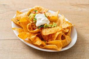 tortilla chips di nachos messicani con jalapeno, guacamole, salsa di pomodori e dip foto