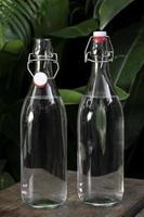 bottiglia d'acqua flip-top in vetro bianco trasparente all'aperto su un tavolo da giardino