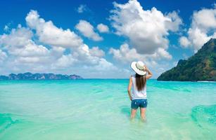 la donna viaggiatrice felice gode in spiaggia tropicale foto