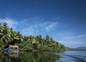 Barca tradizionale e capanna nella giungla sul fiume tatai nelle montagne di cardamomo della Cambogia foto