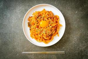 noodles udon saltati in padella con kimchi e maiale - stile alimentare coreano foto