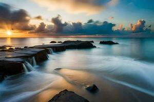 un' bellissimo tramonto al di sopra di il oceano con rocce e acqua. ai-generato foto