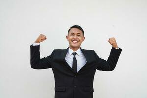 ritratto giovane asiatico uomo d'affari forte gesto, salutare e mostrando muscoli, sollevamento il suo braccio isolato su bianca sfondo foto