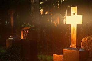 cristianesimo religione simbolo croce splendente nel cimitero foto