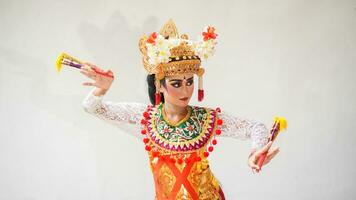 ragazza indossare balinese tradizionale vestito con un' danza gesto su bianca sfondo con -Tenuto in mano fan, corona, gioielleria, e oro ornamento Accessori. isolato balinese ballerino donna ritratto foto