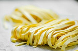 fatti in casa pasta tagliatelle. su bianca tavolo. foto