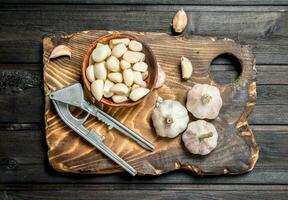 pezzi di aglio nel un' ciotola su un' taglio tavola. foto