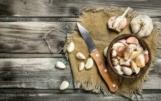 Chiodi di garofano di aglio nel un' ciotola con un' coltello. foto