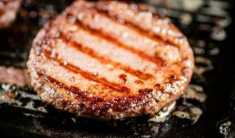 cucinando un' delizioso grigliato hamburger su un' padella con olio bolle. foto