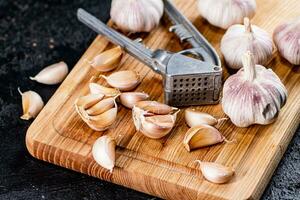 Chiodi di garofano di aglio su un' taglio tavola con un' aglio stampa. foto