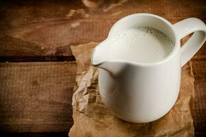 un' brocca di fresco latte su il tavolo. foto