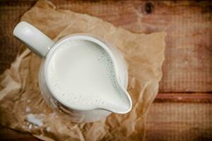 un' brocca di fresco latte su il tavolo. foto