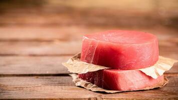 crudo tonno bistecca con carta su il tavolo. foto