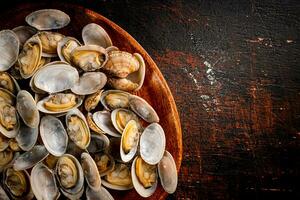 un' di legno piatto pieno di fresco vongole. foto