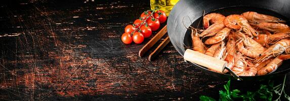 cucinato gamberetto nel un' casseruola con prezzemolo e pomodori. foto