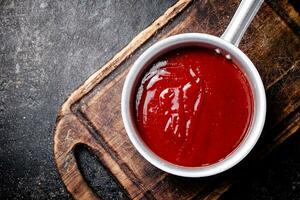 pomodoro salsa su un' di legno taglio tavola. foto