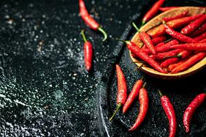 baccelli di caldo chili peperoni su un' taglio tavola. foto