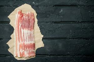 crudo Bacon su carta. foto