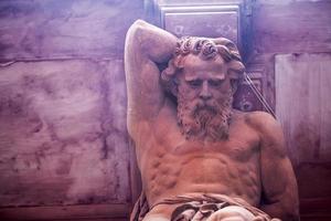 statua del dio greco su un edificio in mattoni foto