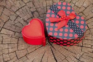 confezione regalo a forma di cuore su tronco di legno