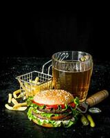 hamburger con birra, patatine fritte e cetriolini. foto