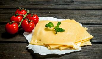 magro fette di formaggio con pomodori e un' ramo di menta. foto