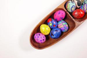 pasquali colorate uova di pasqua in un piatto di legno foto