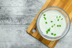 acida crema nel ciotola con verde cipolle. foto