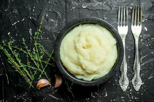 schiacciato patate nel un' ciotola con aglio e timo. foto