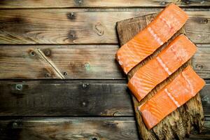 crudo salmone pesce bistecche su un vecchio taglio tavola. foto