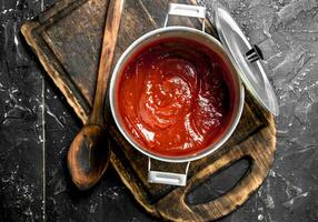 pomodoro salsa nel un' pentola su un' taglio tavola. foto