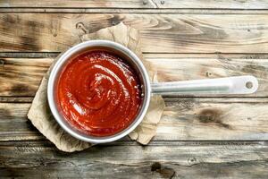 pomodoro salsa nel un' casseruola su carta. foto