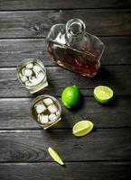 whisky nel un' bottiglia e bicchieri di ghiaccio e fette di lime. foto