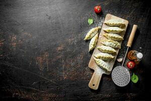 gedza Ravioli con carne su un' taglio tavola. foto