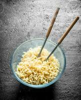 caldo immediato tagliatelle nel ciotola con bacchette. foto