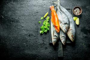 fresco mare pesce con lime fette, prezzemolo e spezie. foto