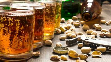 quattro birre con pistacchi su un' di legno tavolo. foto