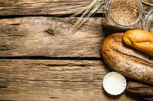 fresco pane con Grano grani. su di legno tavolo. foto