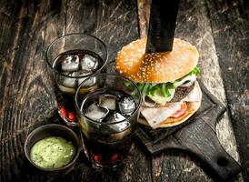 strada cibo. grande hamburger con Coca Cola e salsa. foto