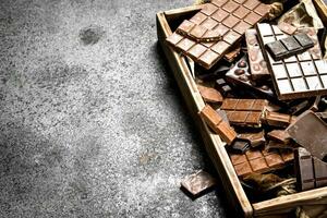 rotto cioccolato barre su di legno vassoio. foto