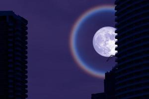 luna blu superfrutta con edificio stagliato nel cielo notturno foto