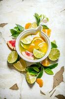 il succo a partire dal agrume frutta - Uva, arancia, mandarino, Limone, lime nel un' tazza con le foglie. foto