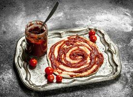 preparazione di Pizza. applicazione di pomodoro salsa su il lanciato Impasto. foto