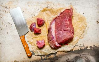 taglio fresco crudo carne su carta. su rustico sfondo. foto