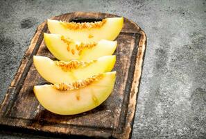 fette di fresco melone su il vecchio tavola. foto