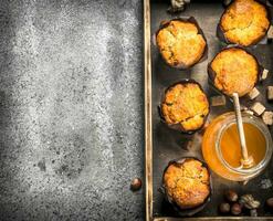 miele muffin con noccioline su un vecchio vassoio. foto