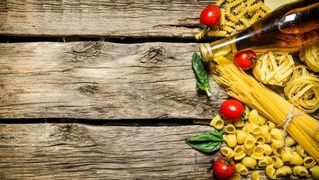 misto asciutto pasta e spaghetti, con pomodori, erbe aromatiche e oliva olio. foto