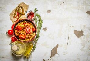 spaghetti con pomodoro incolla, caldo chili peperoni e oliva olio. foto