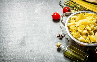 bollito pasta nel il padella con oliva olio e pomodori. foto