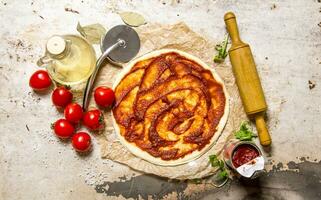 Pizza Impasto con pomodoro incolla e un' rotolamento spillo. foto